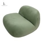 Sage green sculptural velvet lounge chair with a rounded low-profile design