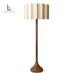 Sculptural wood table and floor lamps with ivory pleated fabric shades