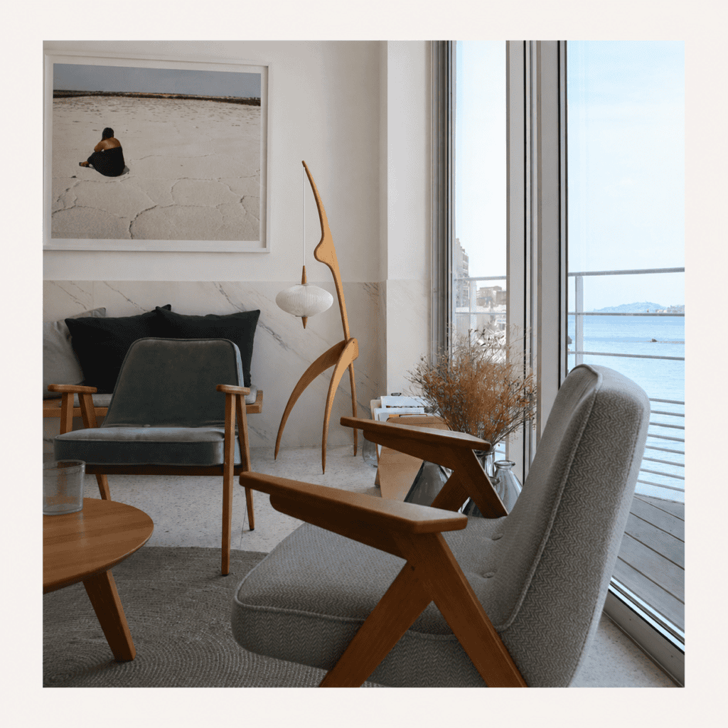 noguchi-hanging-floor-lamp-living-room-view-2 Wooden hanging floor lamp beside lounge chairs in a bright living room